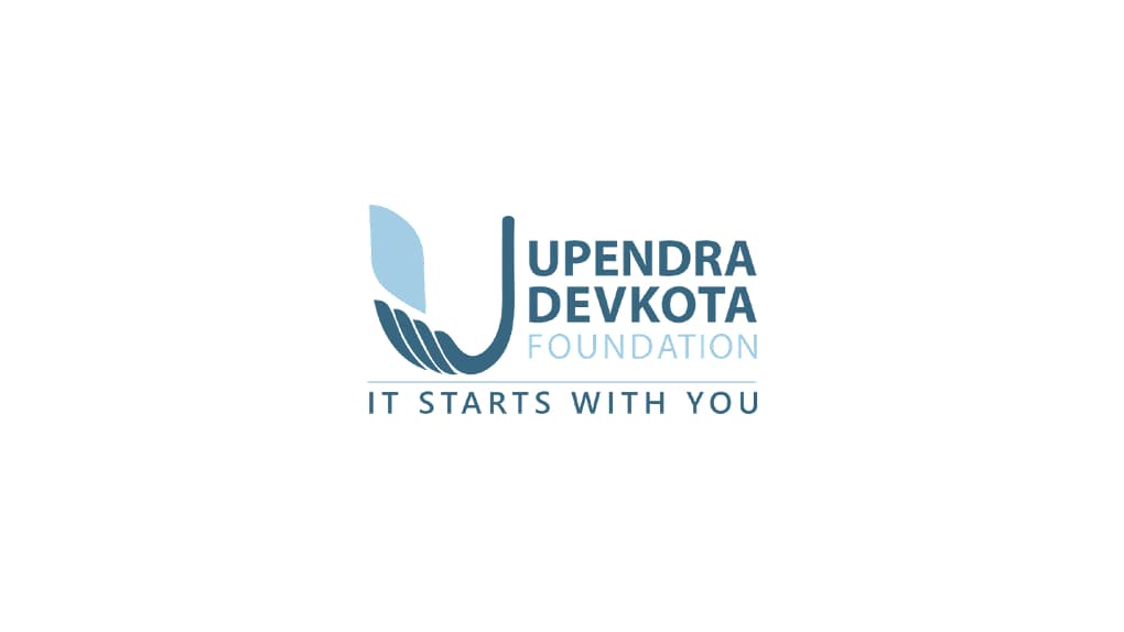 The logo of the Upendra Devkota Foundation featuring a stylized 'U' forming a hand cradling a leaf, with the words 'UPENDRA DEVKOTA FOUNDATION' next to it, and the slogan 'IT STARTS WITH YOU' below.